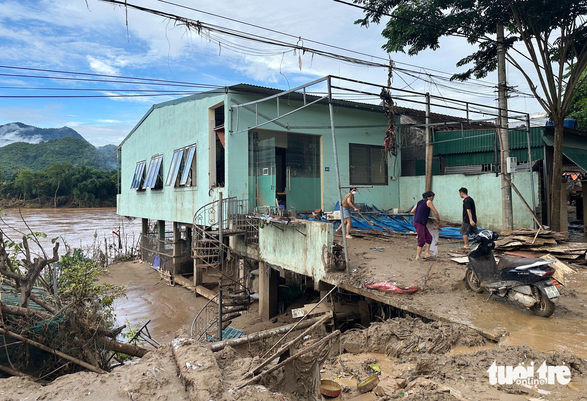 义安洪水区居民在厚厚的泥浆中寻找财产