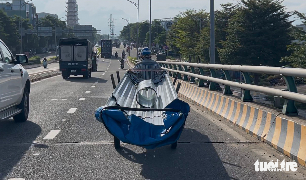 三轮车拉着近十米长的铁皮在岘港街头横行