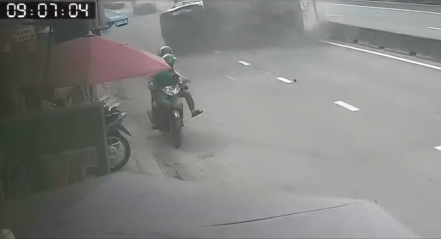 在胡志明市，卡车突然侧翻，两名摩托车骑手瞬间脱险