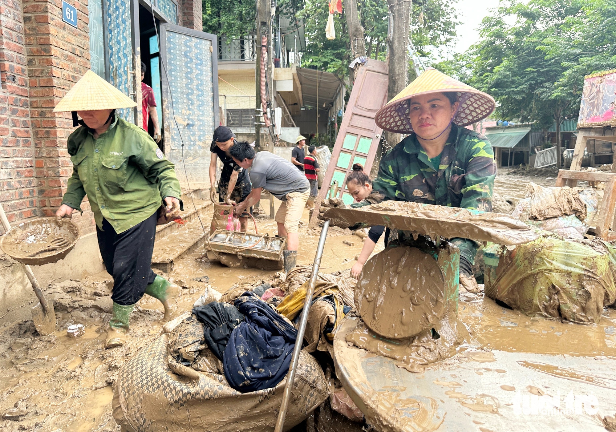 义安洪水区居民在厚厚的泥浆中寻找财产