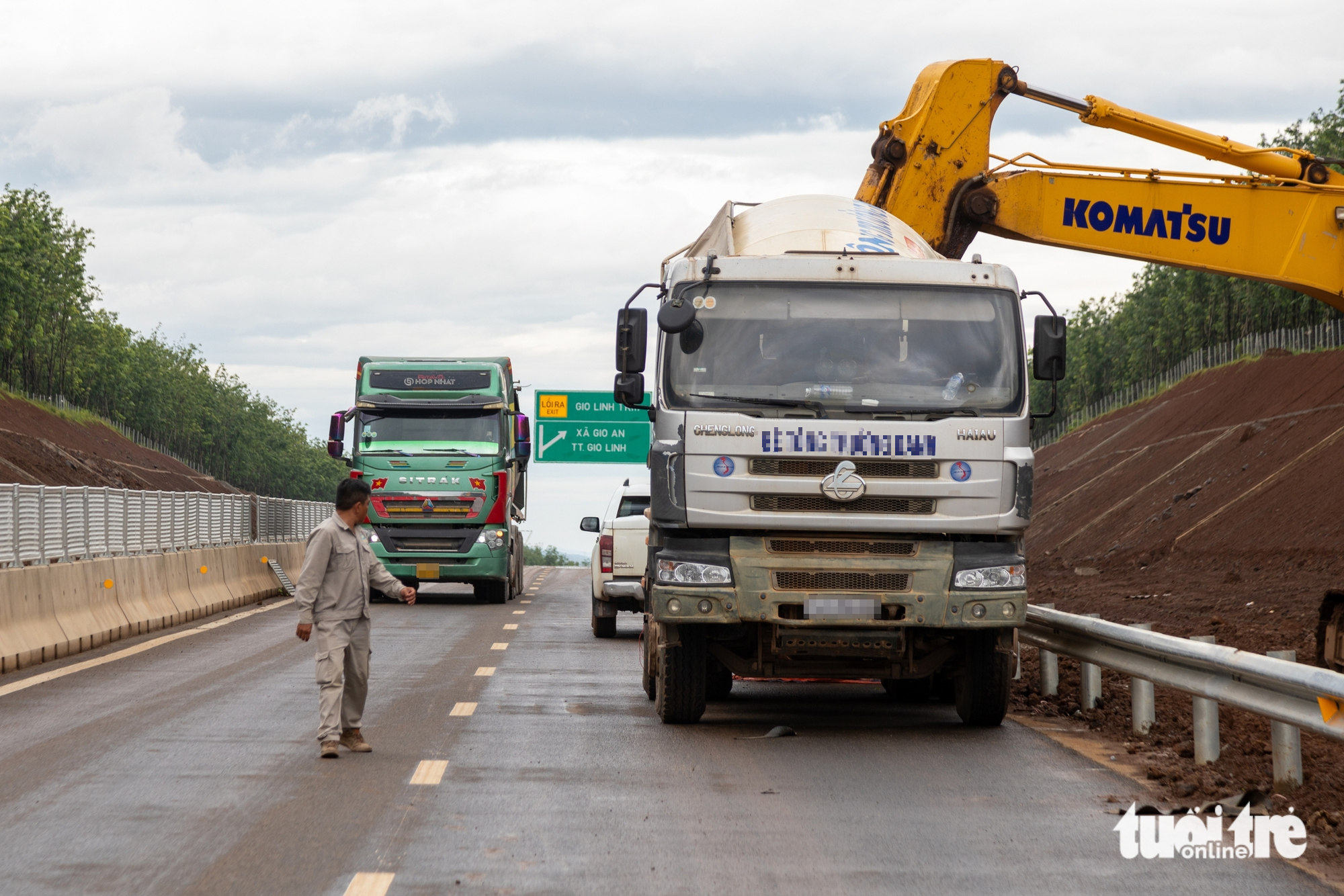 未开通的高速公路上牵引车、汽车川流不息，工人边工作边颤抖