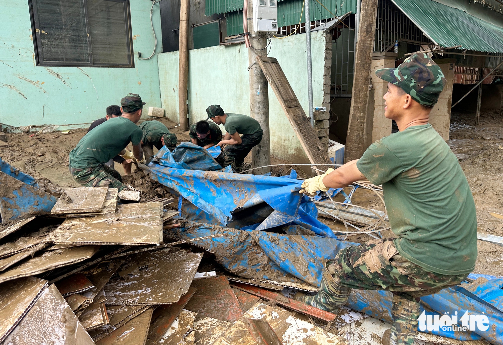 义安洪水区居民在厚厚的泥浆中寻找财产